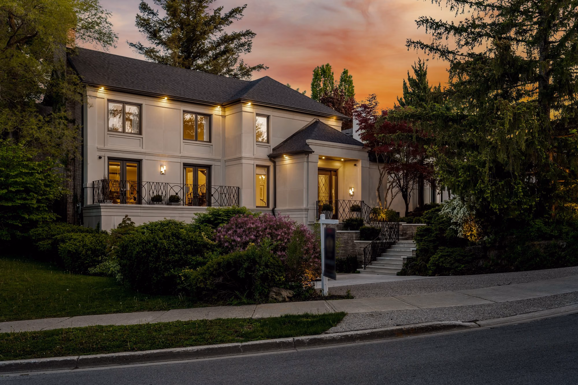 Home exterior at dusk with driveway and stone steps