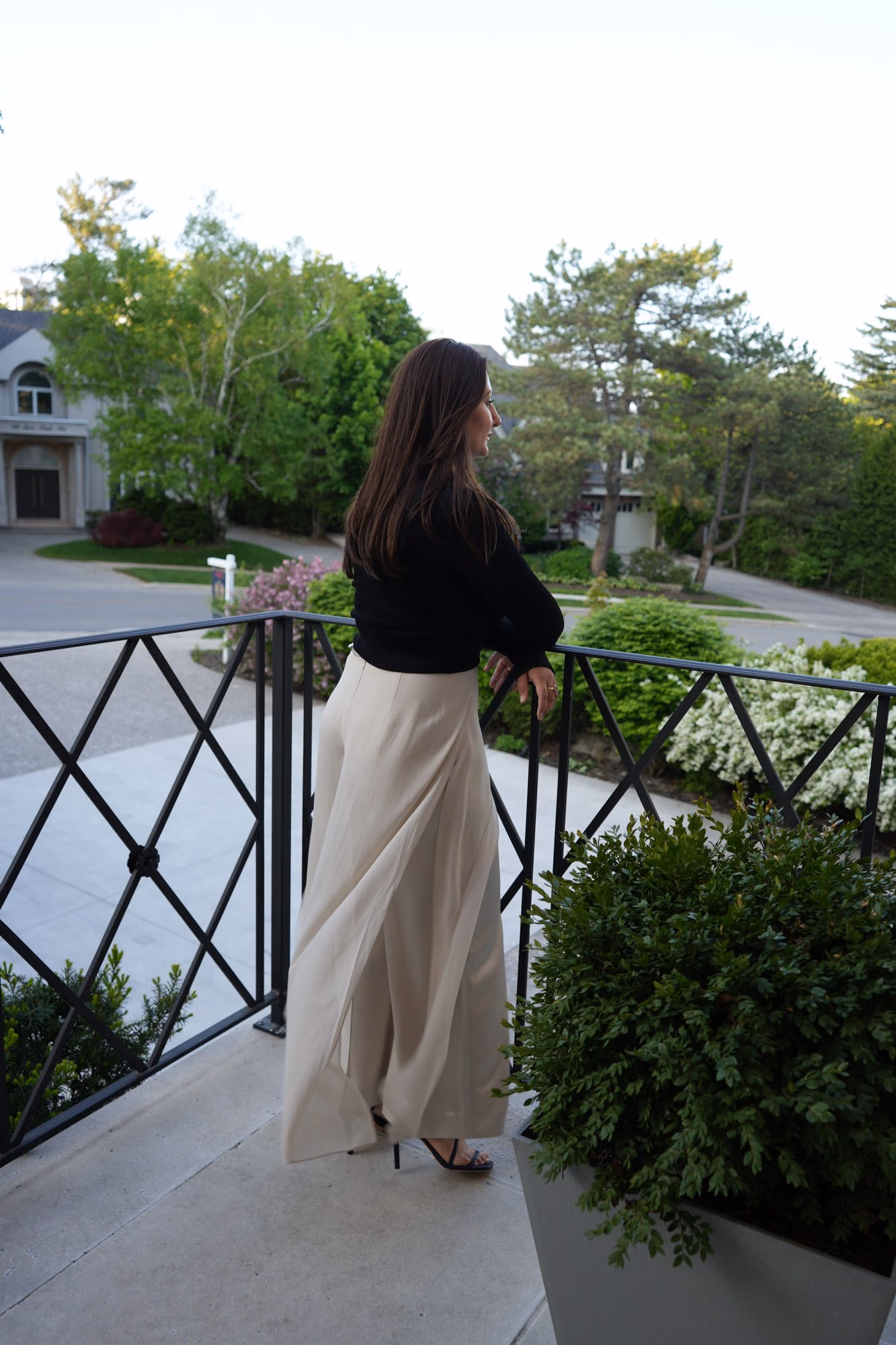 Woman on a balcony railing overlooking the street