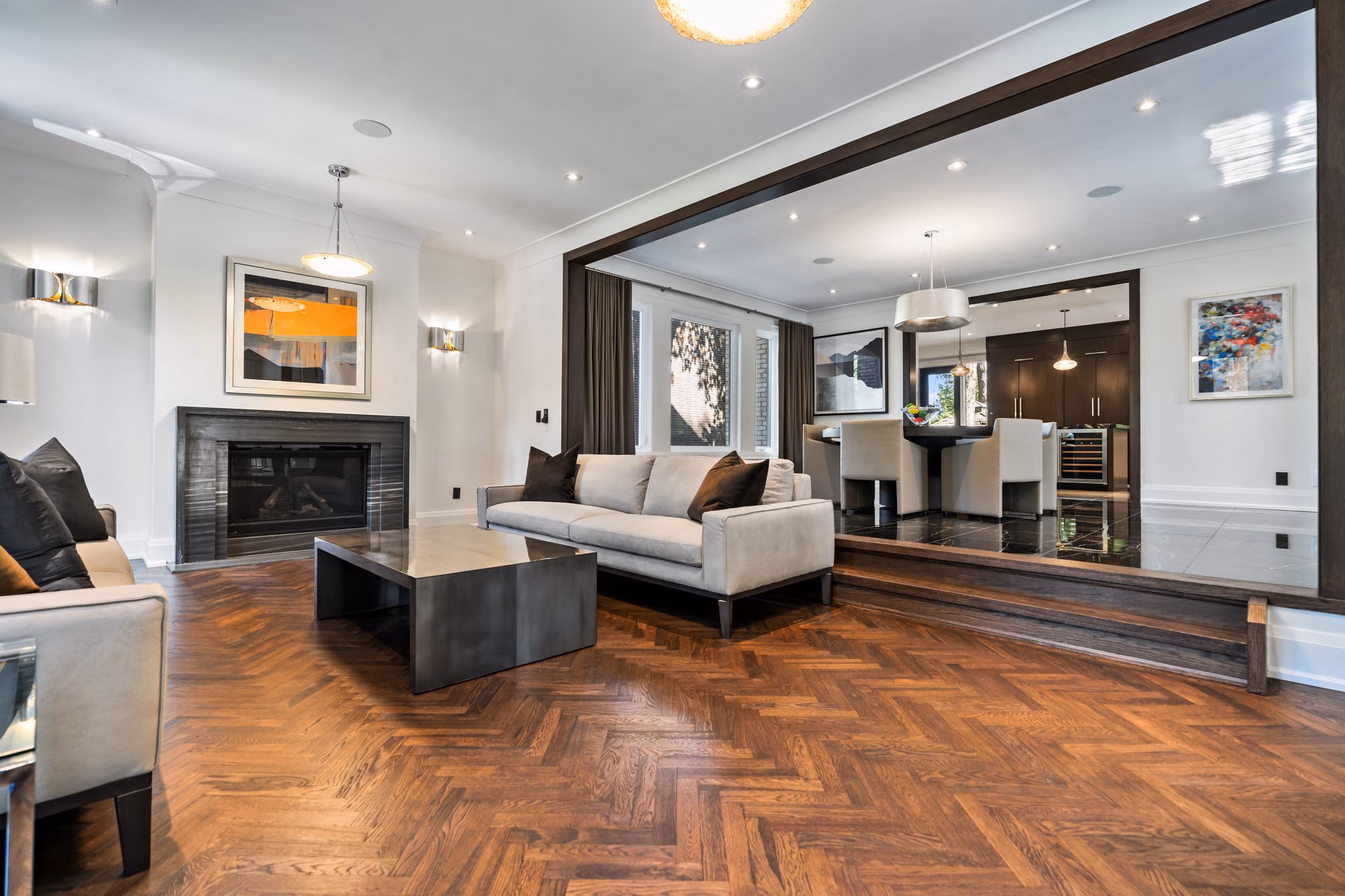 Living room with herringbone floor and double-sided fireplace