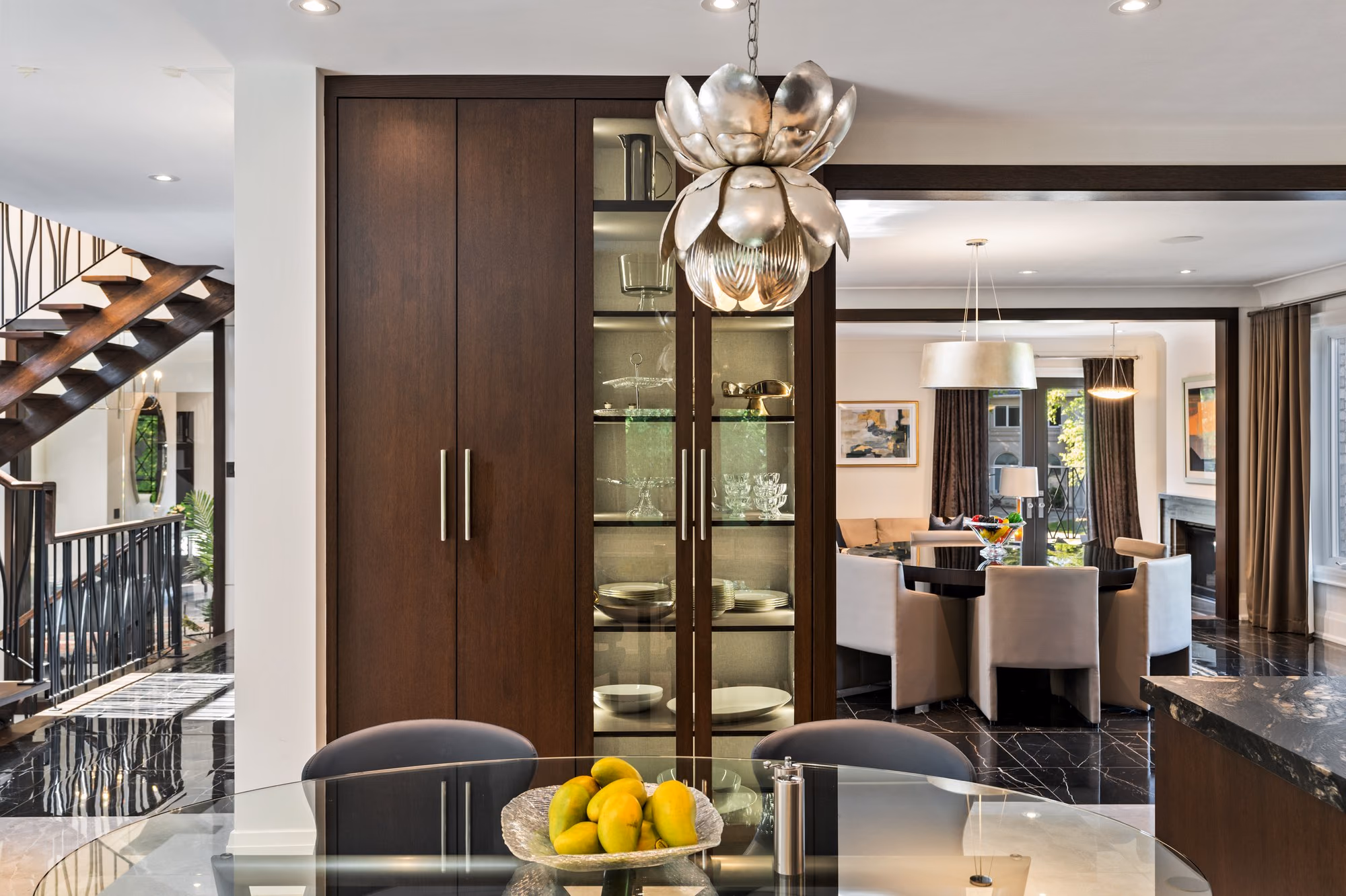 Staircase landing and dark wood display cabinet beside the dining table