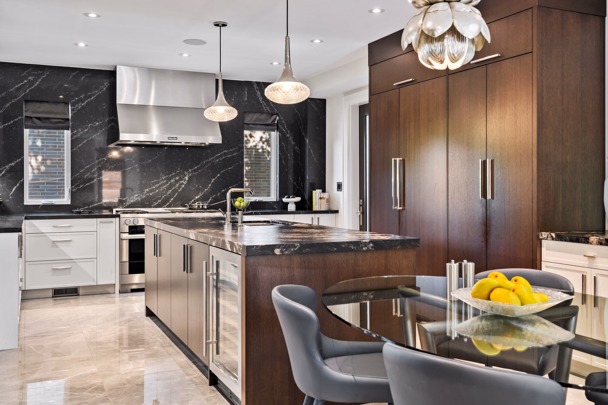 Kitchen with wood island, pendant lights and dark marble backsplash