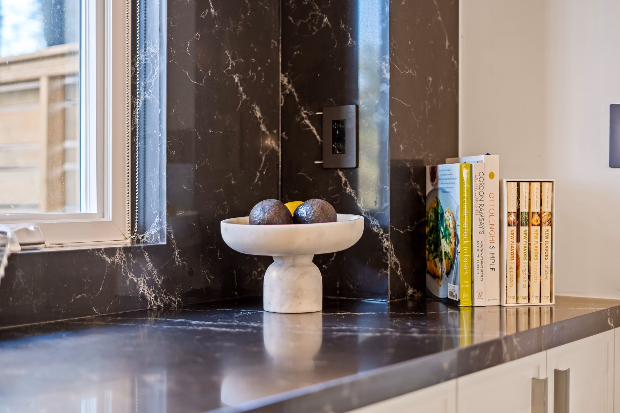 Dark stone countertop and backsplash with styled objects