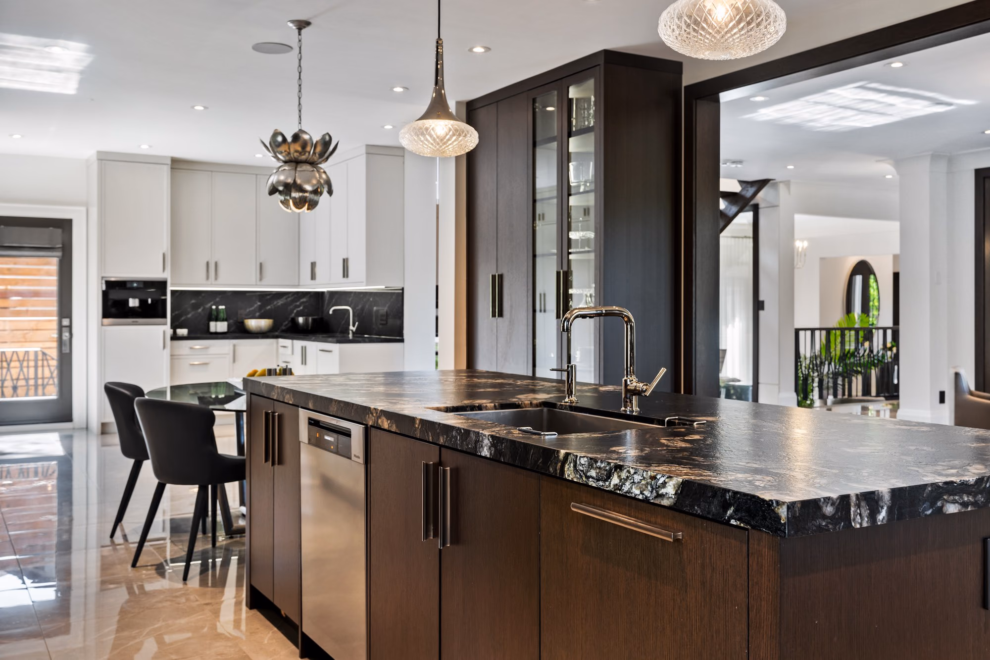 Kitchen island with dark wood cabinetry and black stone counter