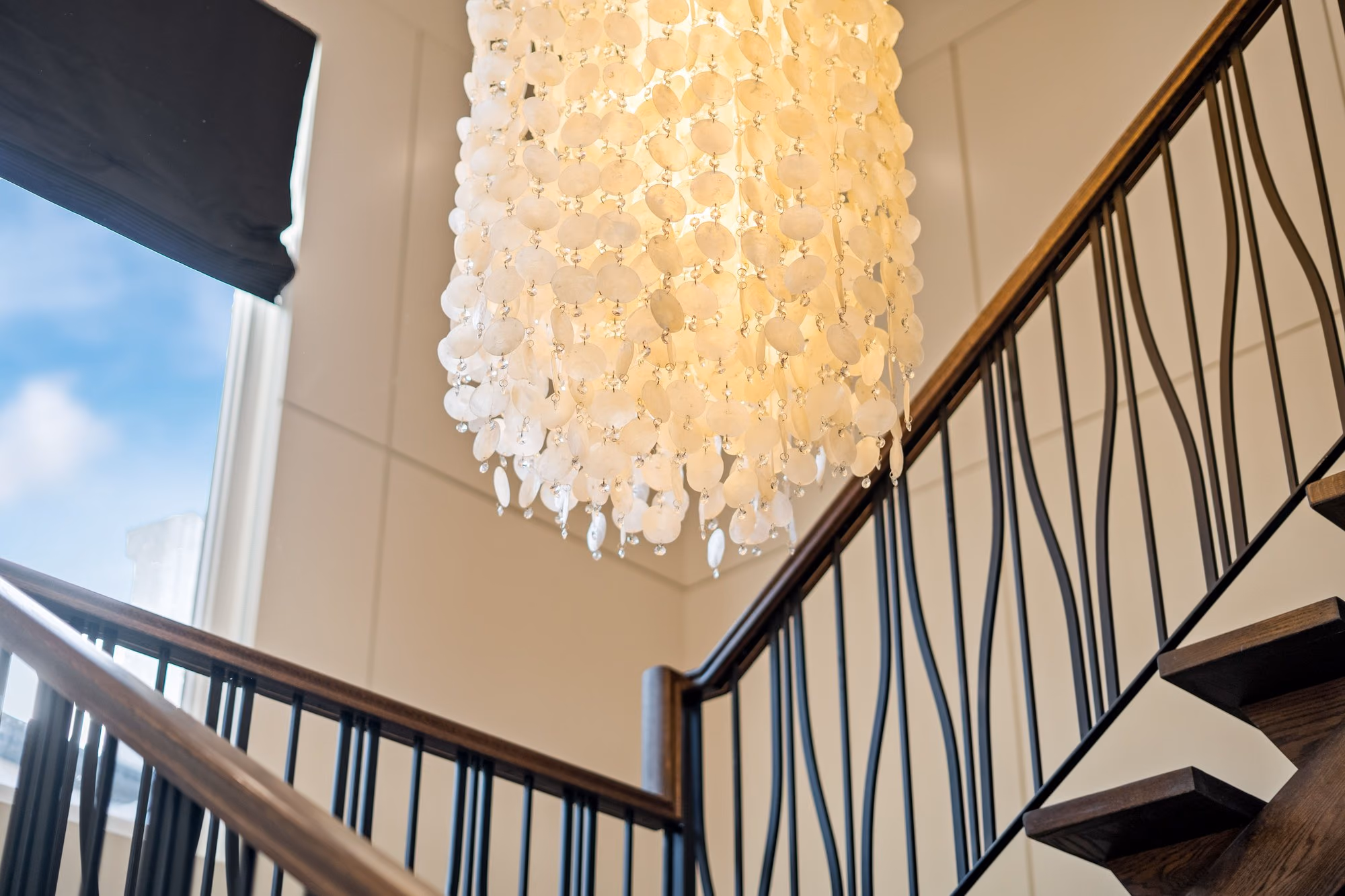 Capiz shell chandelier above the staircase