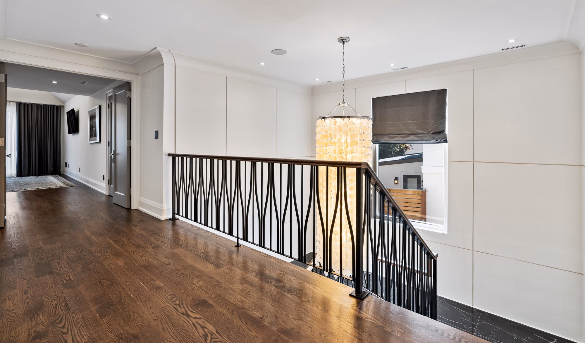 Upper hallway with iron railing and wood floors