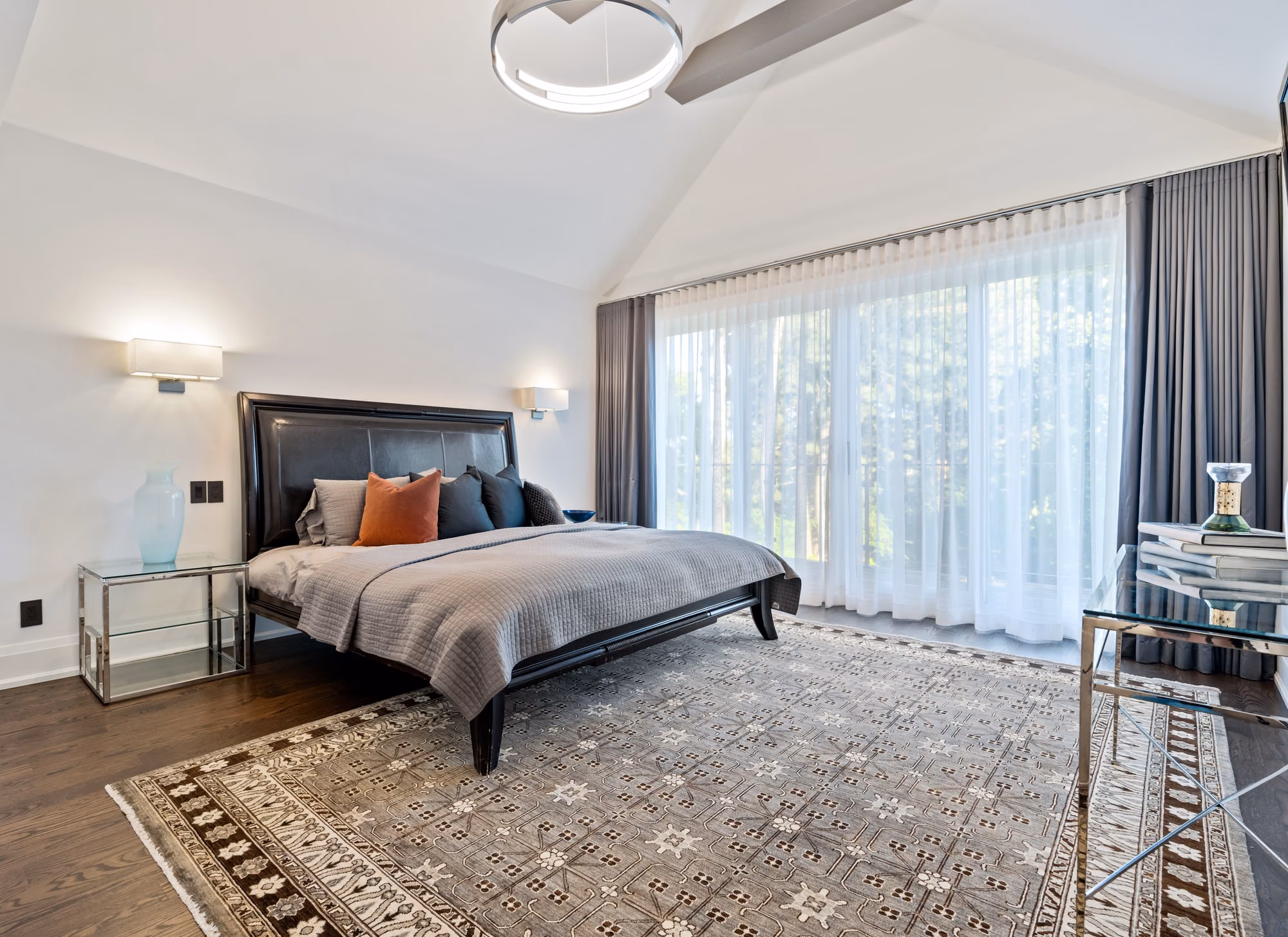 Primary bedroom with upholstered bed and patterned rug