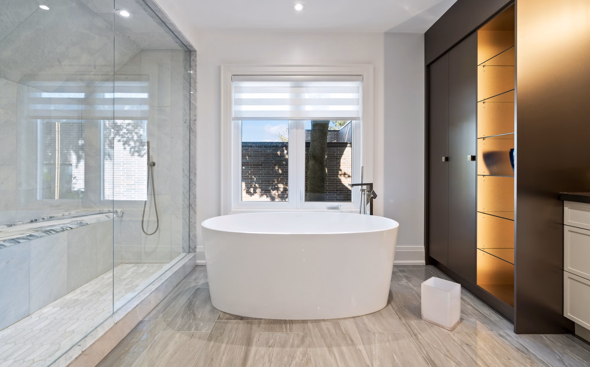 Freestanding bathtub beside a glass shower