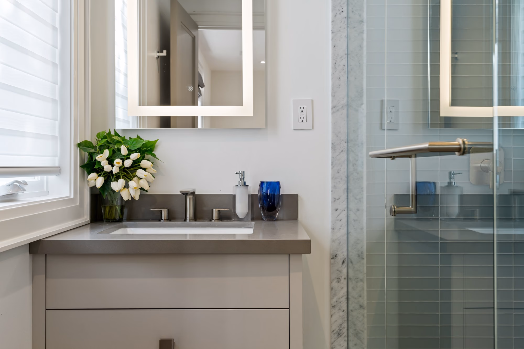 Bathroom vanity with glass shower behind