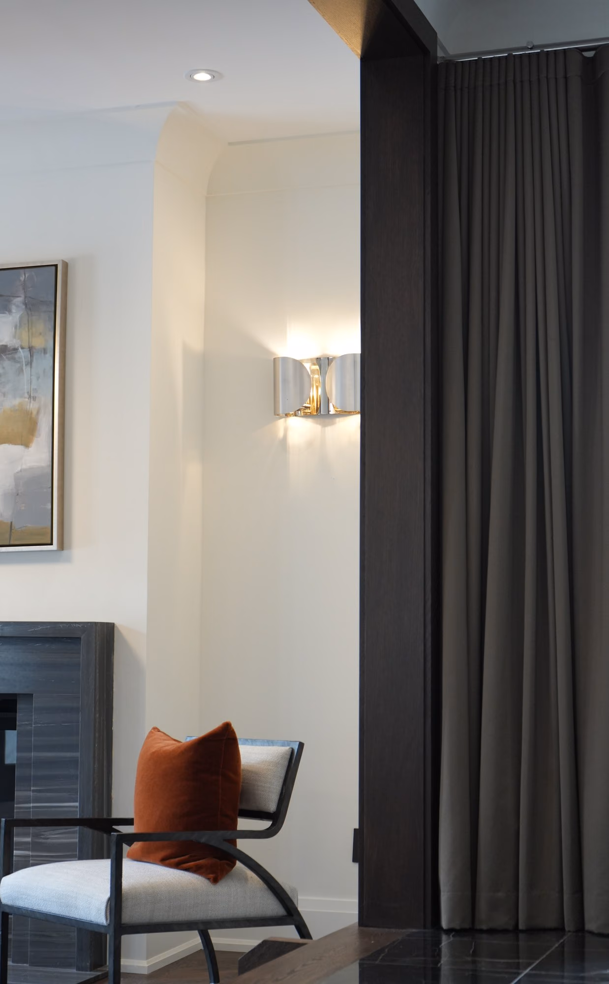 Bedroom corner with sconce and Barcelona chair