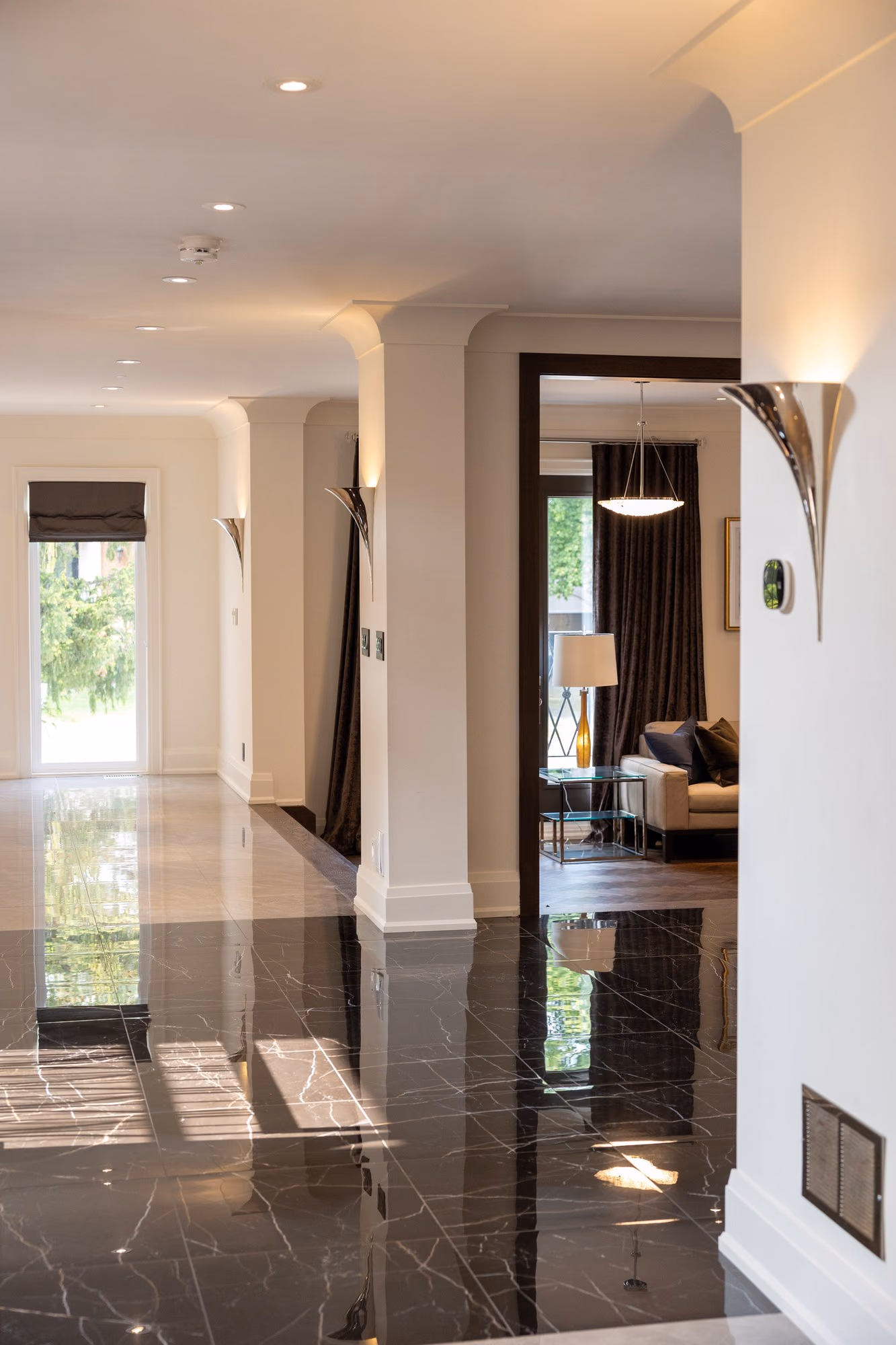 Hallway with black marble floor and arched mirror