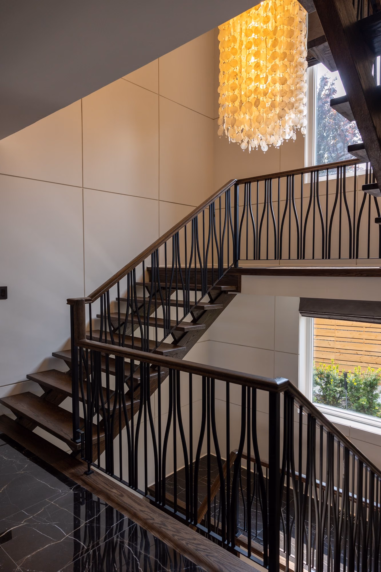 Staircase with wavy iron balusters seen from the upper landing