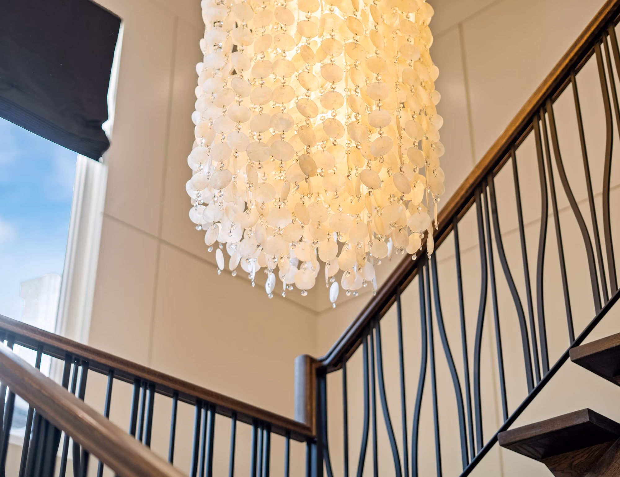 Capiz shell chandelier above the staircase