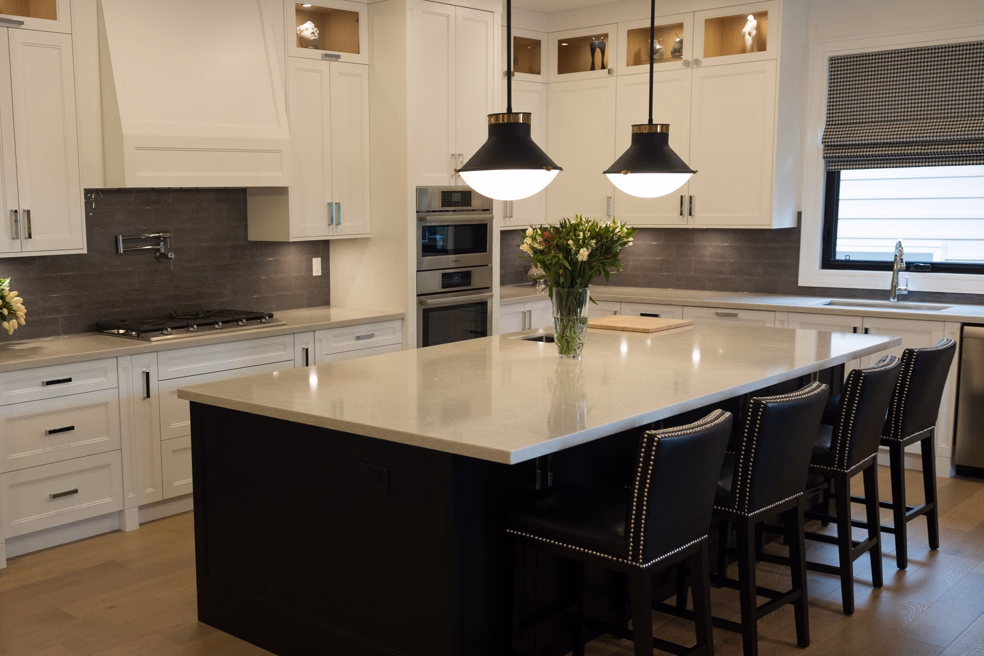 Farmhouse kitchen island with pendant lights and black stools