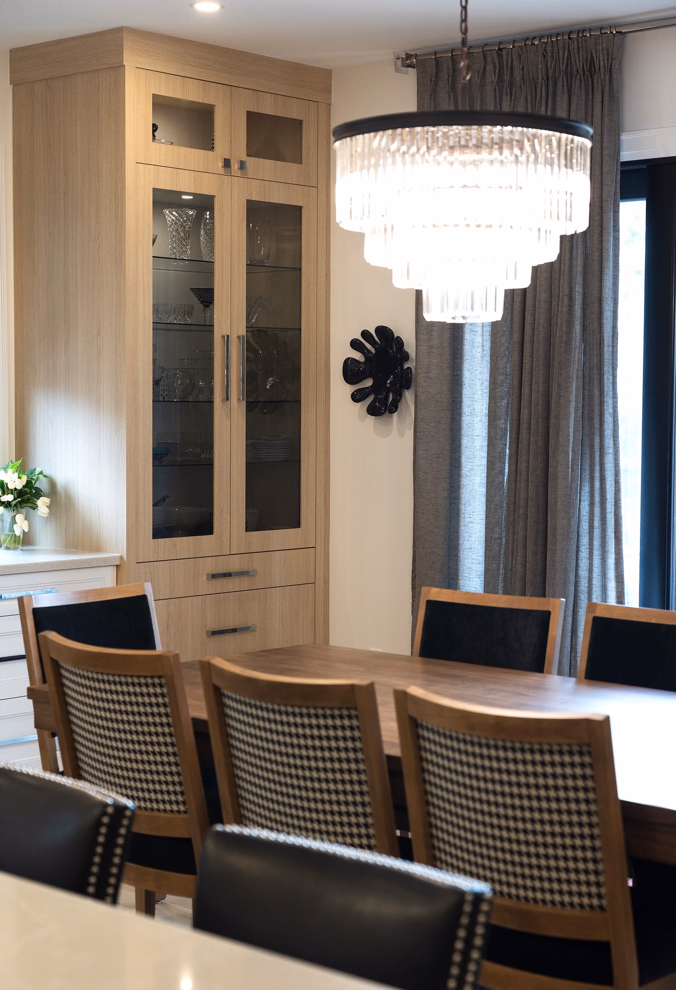 Farmhouse dining room with crystal chandelier and display cabinet