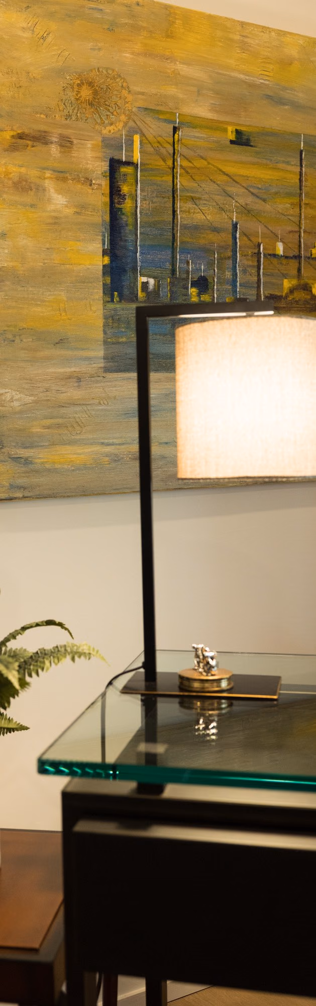 Console with artwork and glass lamp