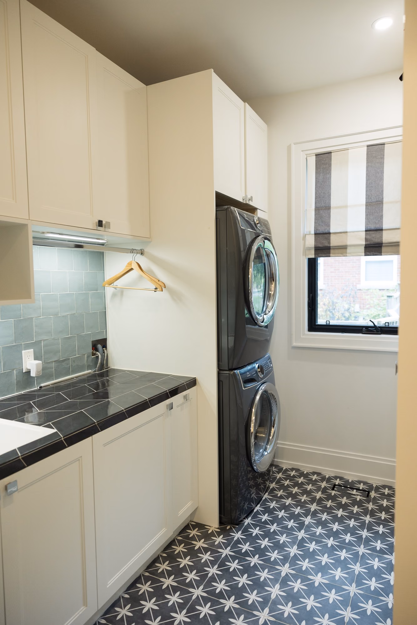 Farmhouse laundry room with black tile counter