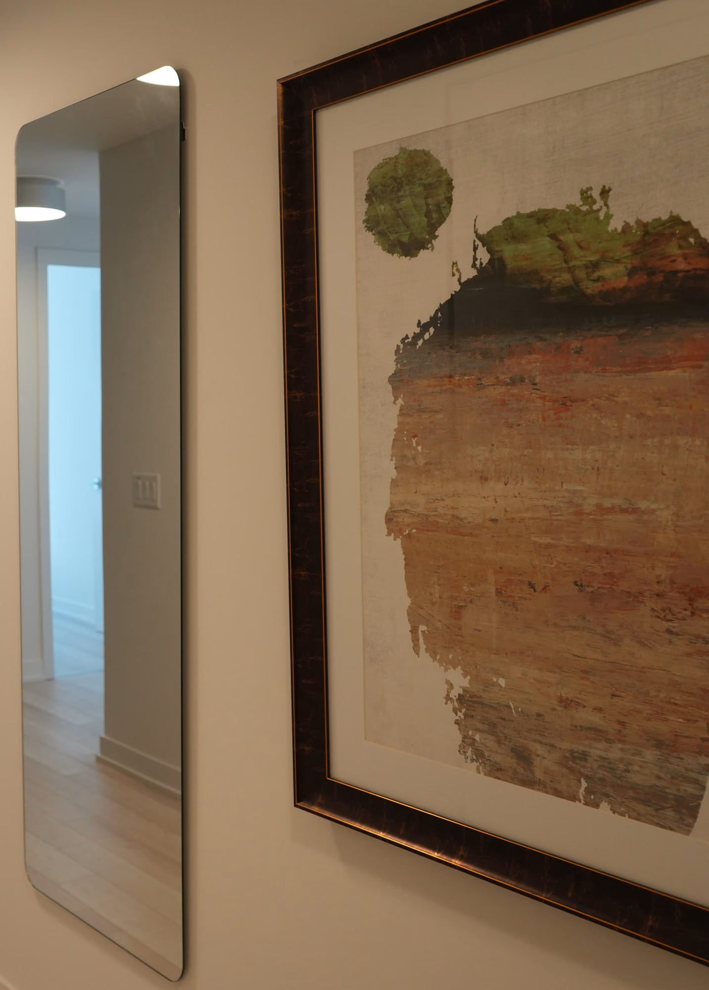 Condo interior with leaning mirror, bench and artwork