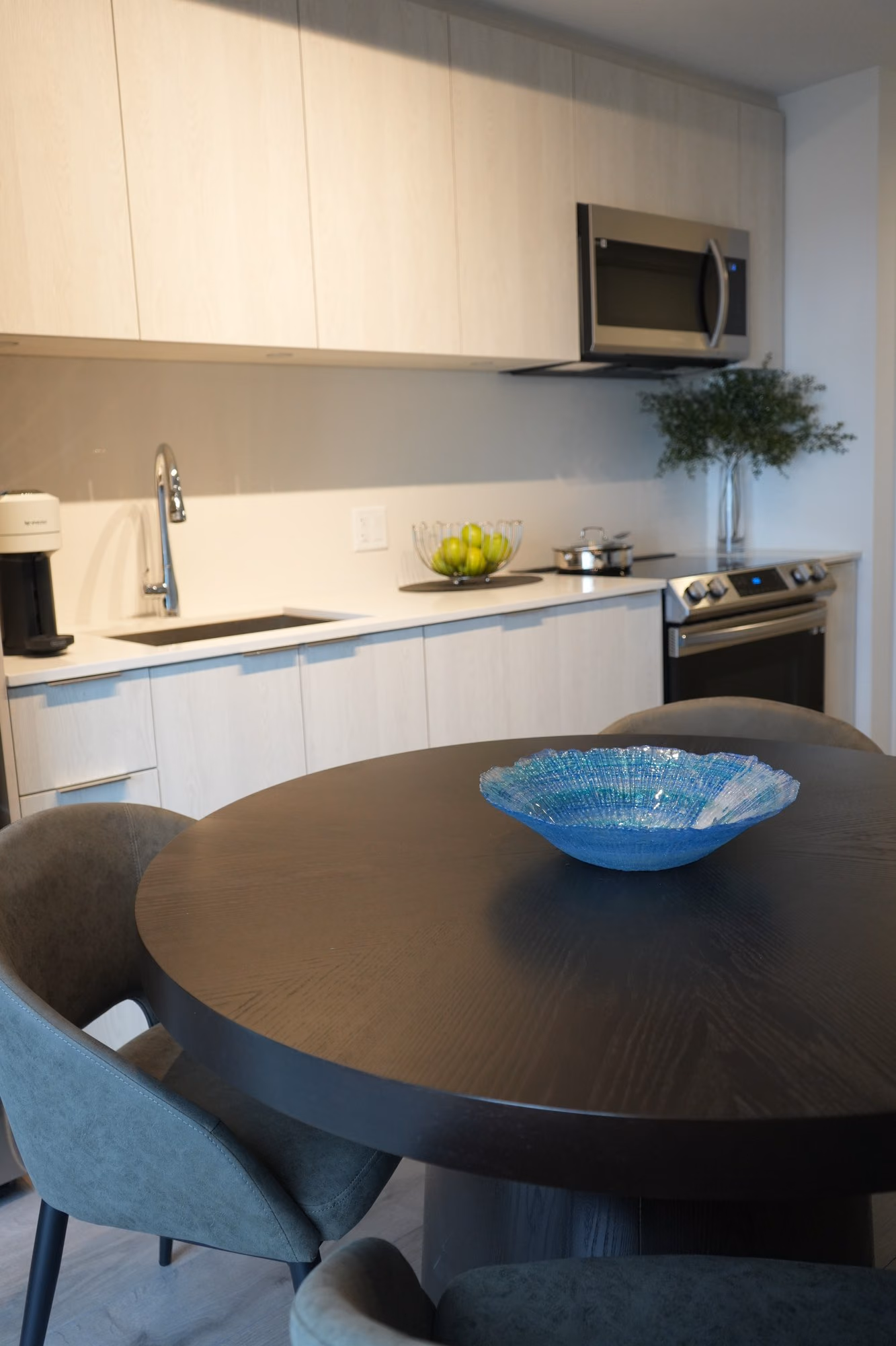 Condo kitchen with round dining table and blue bowl