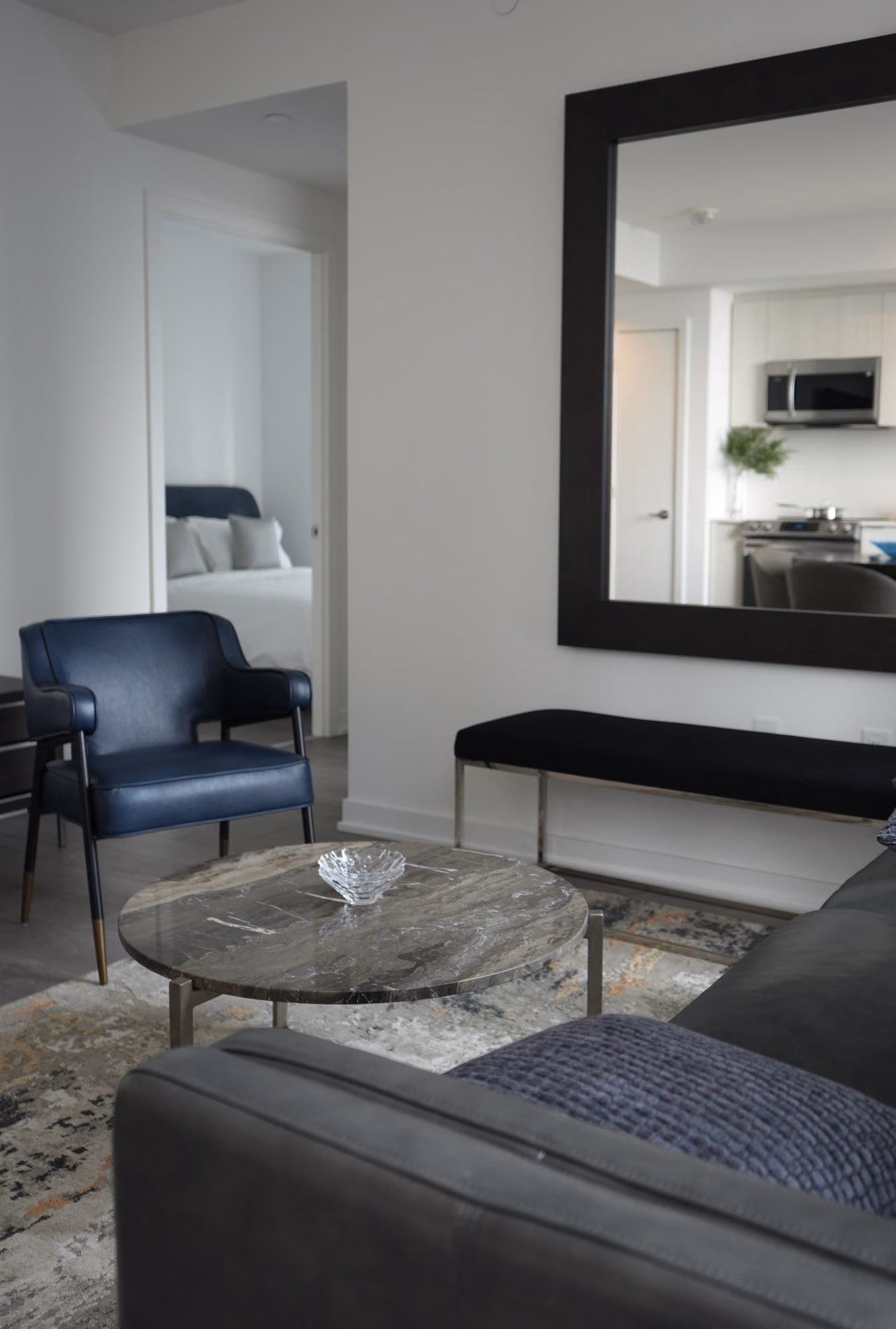 Condo living room with large framed mirror and bench
